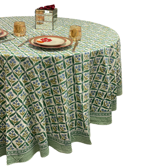 Patterned tablecloth on a round table with place settings and glasses.