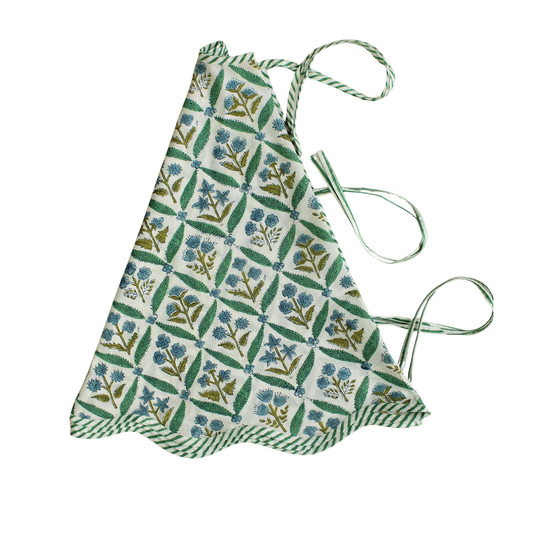 Floral patterned apron with green straps on a white background
