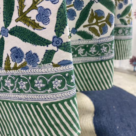 Close-up of patterned fabric with green, blue, and white design.