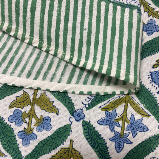 Close-up of green and white striped fabric with floral patterned fabric underneath
