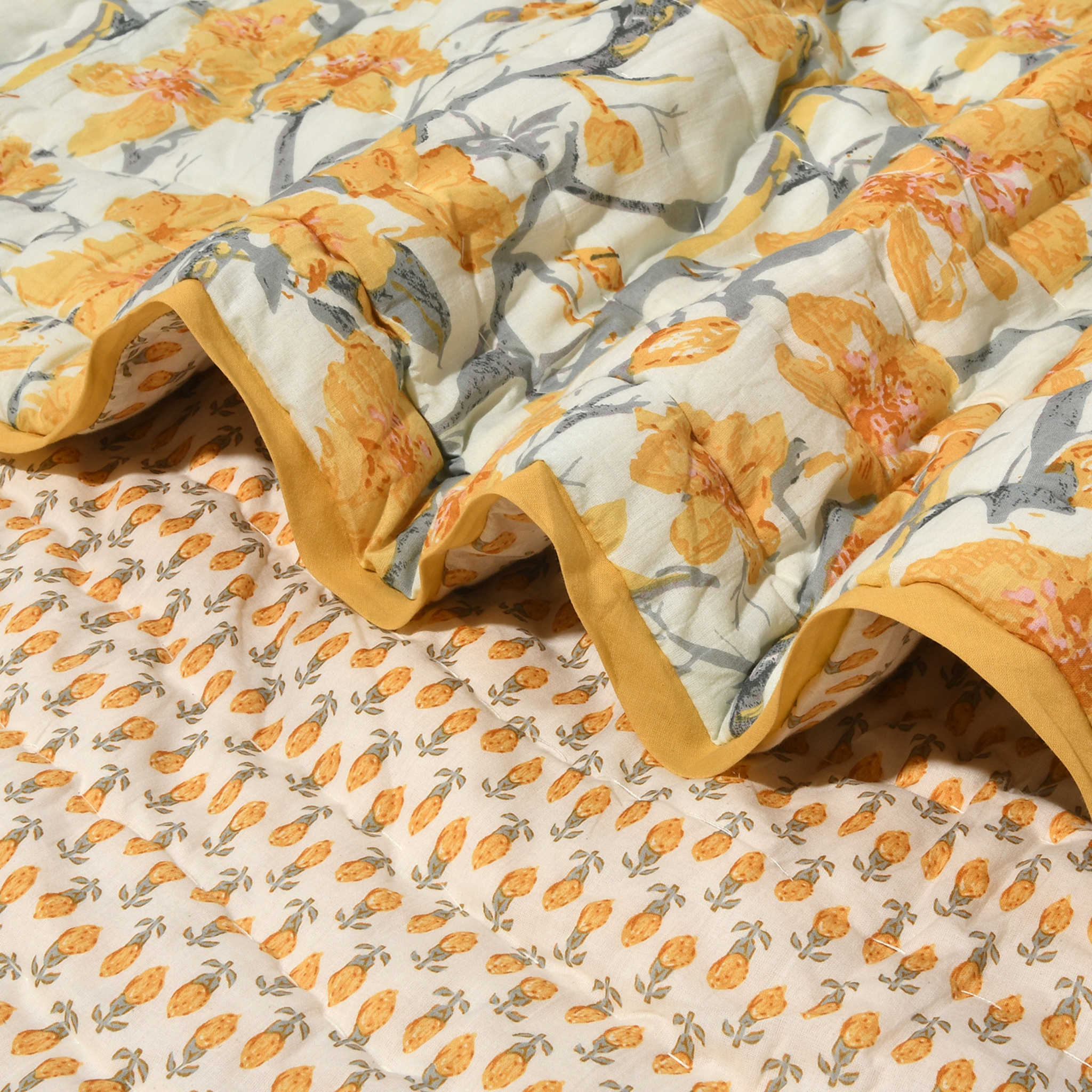 Floral patterned fabric with yellow and gray flowers on a beige background