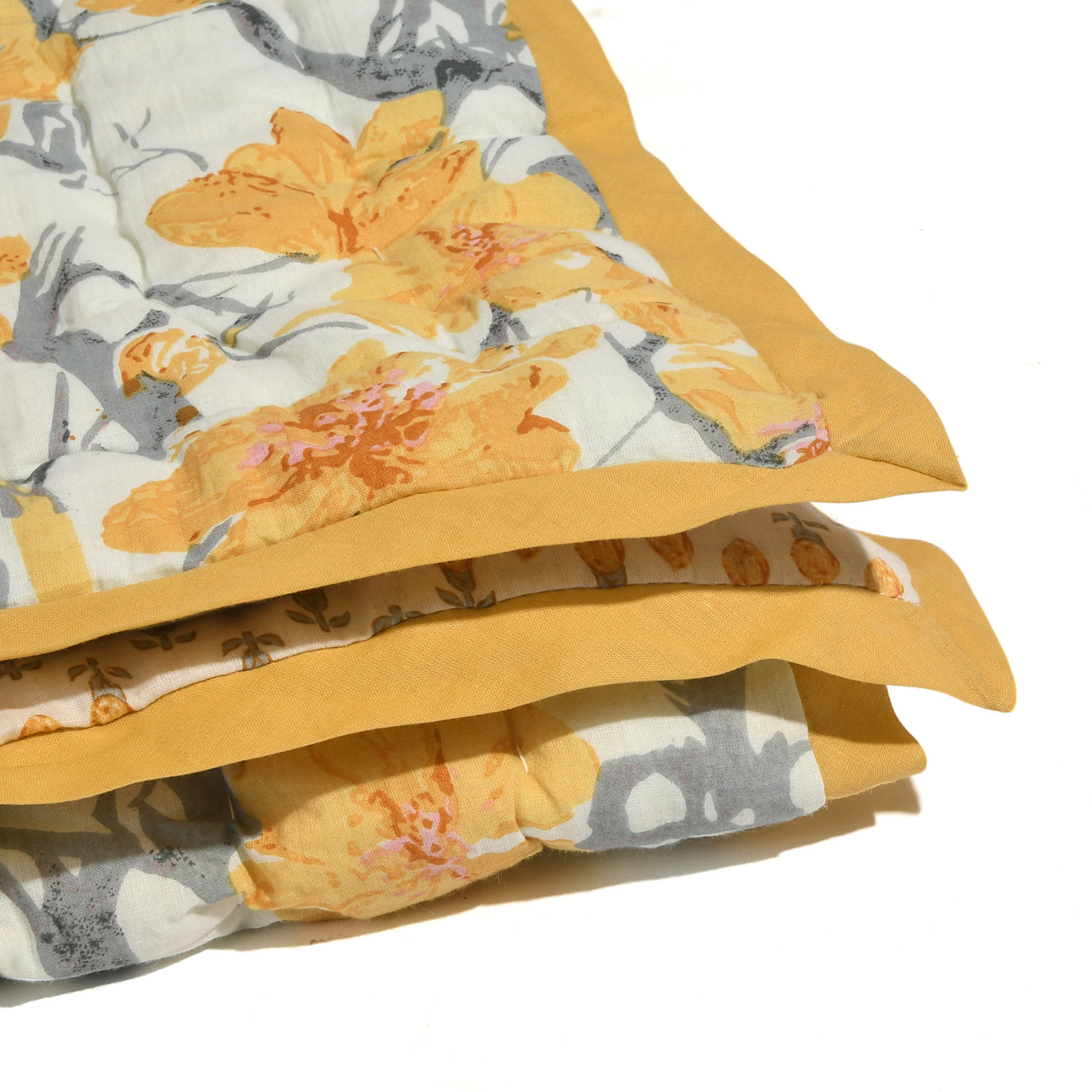 Stack of floral-patterned fabric with yellow border on a white background