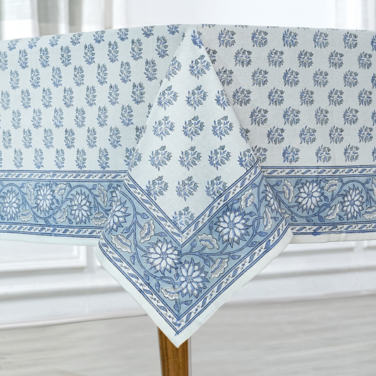 Blue floral patterned tablecloth on a wooden table with a white background