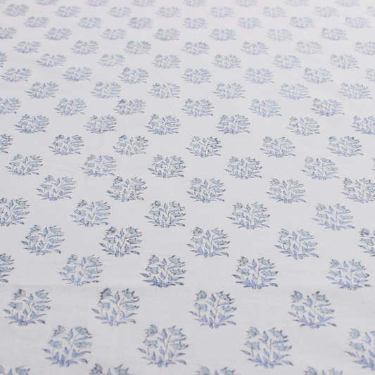 Patterned fabric with small blue floral designs on a light blue background