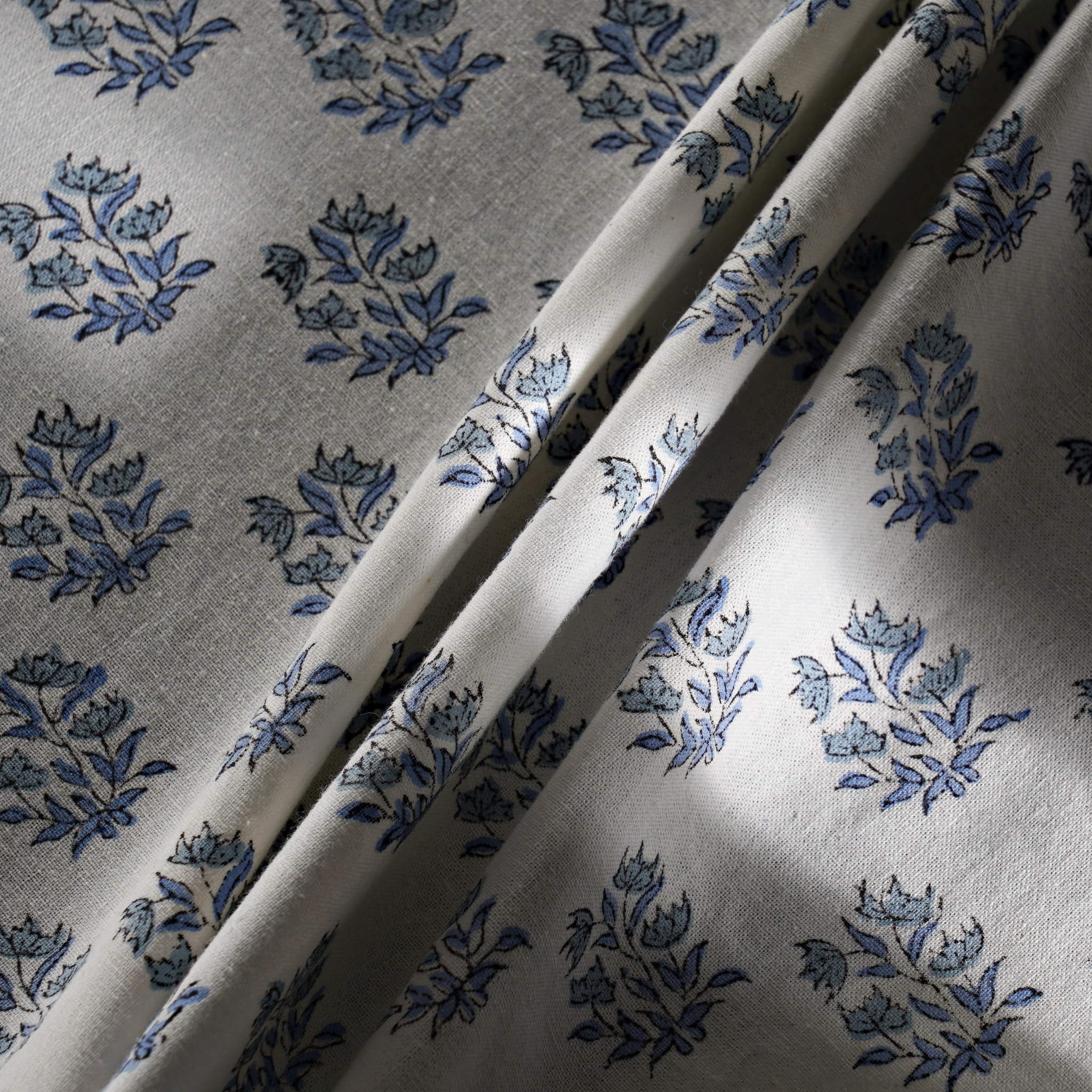 Floral patterned fabric with blue flowers on a gray background