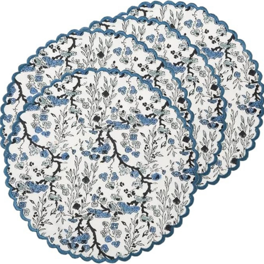 Set of floral-patterned placemats with scalloped edge on a white background