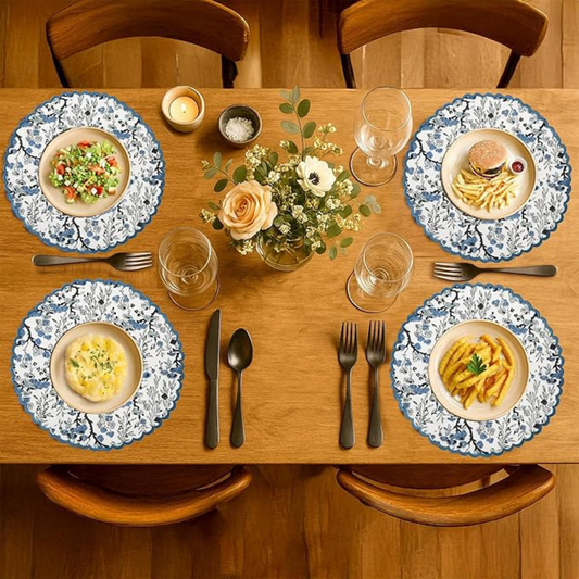 Dining table set with plates, cutlery, and a centerpiece on a wooden table.
