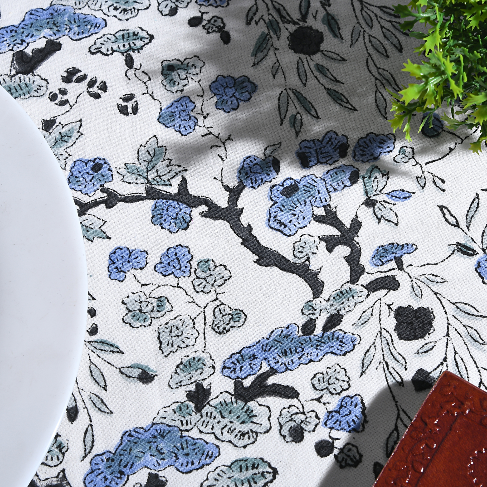 Floral patterned fabric with blue and black flowers on a white background