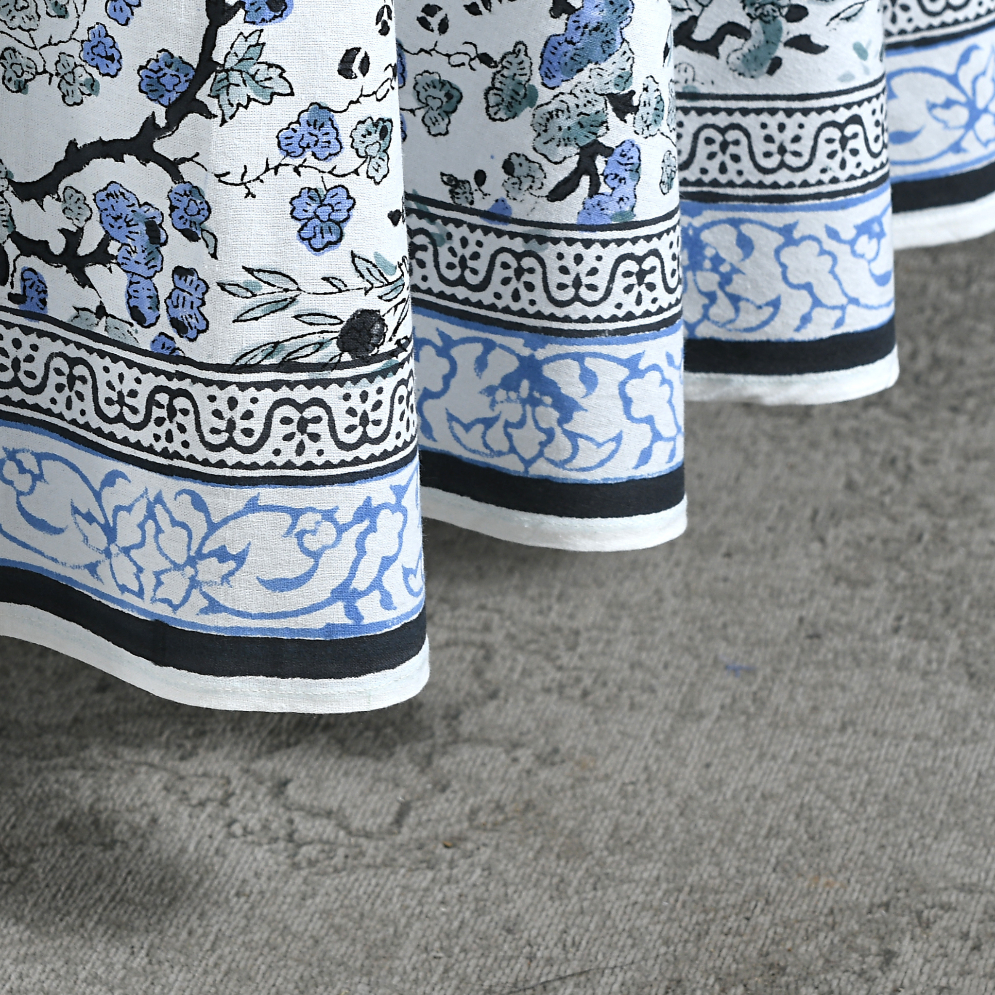 Close-up of a fabric with blue and black floral patterns on a gray surface