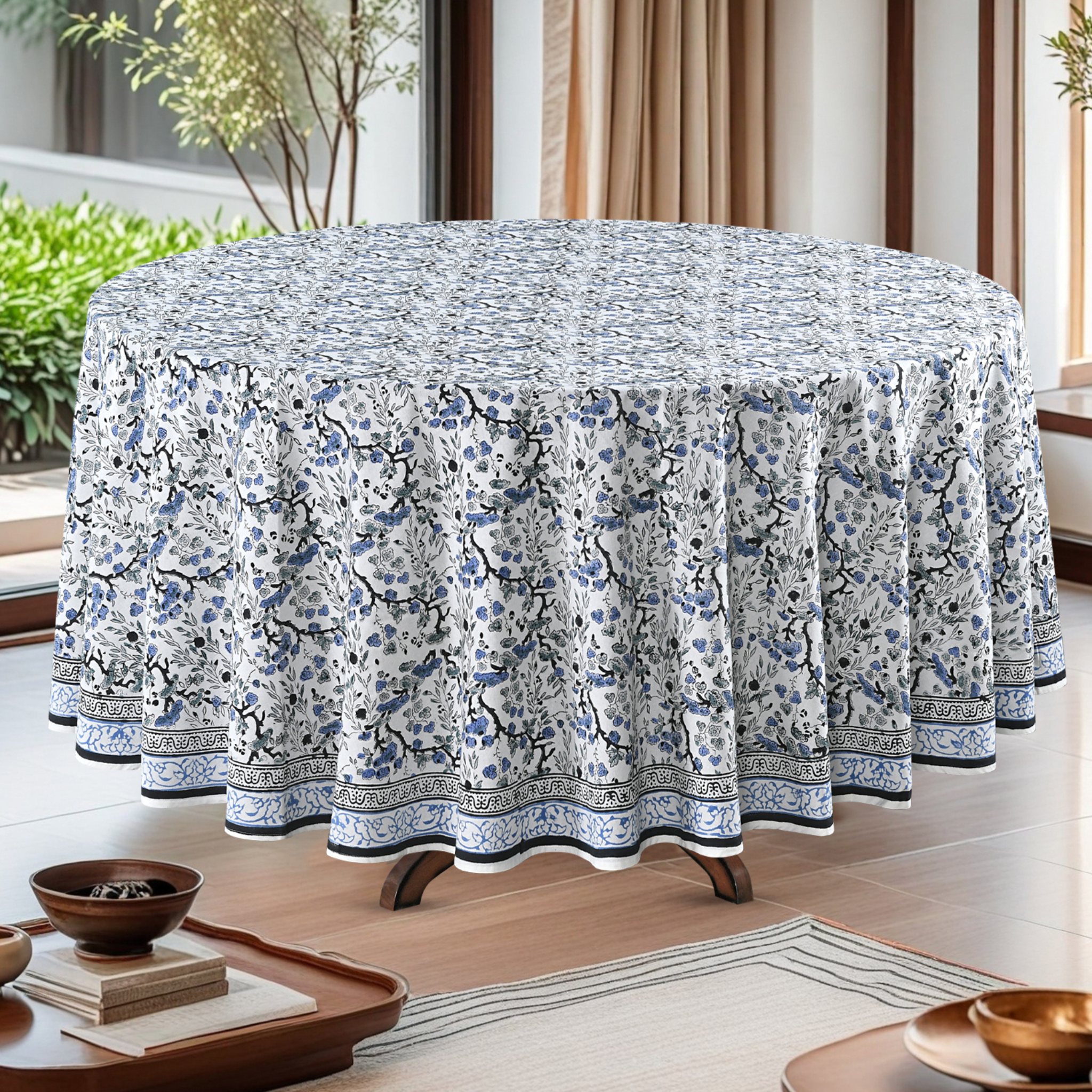 Round table with a floral patterned tablecloth in a bright room.