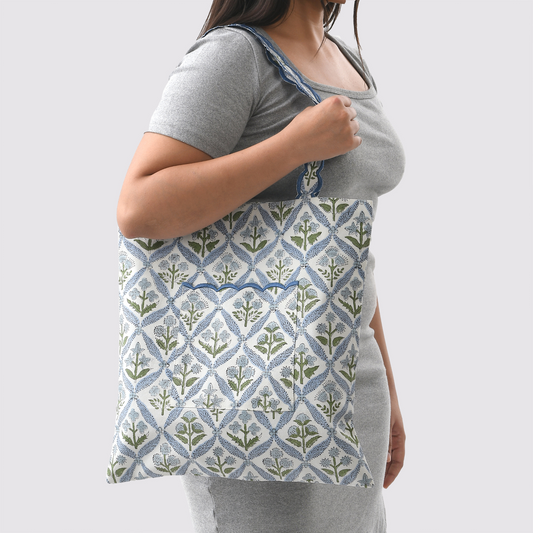 Person wearing a gray shirt with a patterned apron on a white background