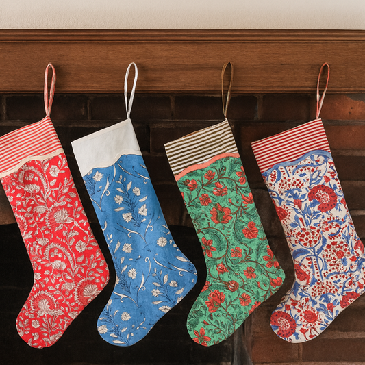 Four patterned stockings hanging on a fireplace mantle.