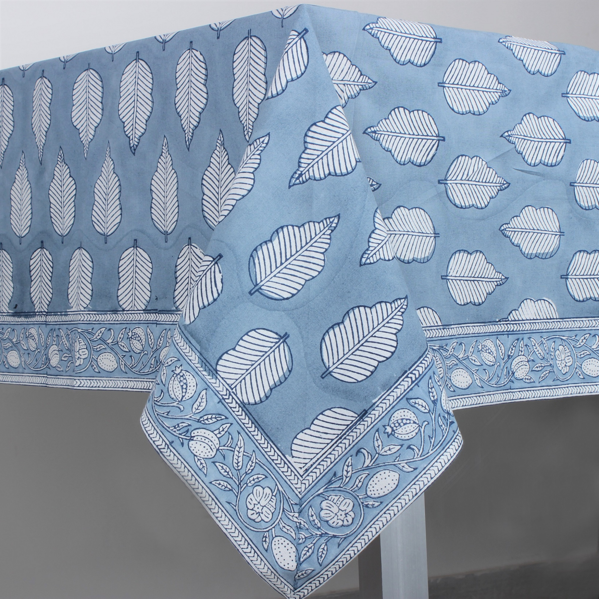 Blue tablecloth with white leaf pattern on a gray background