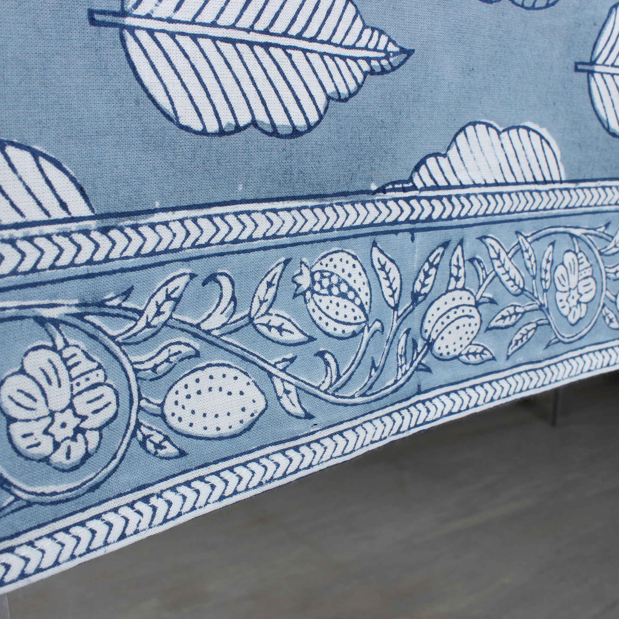 Decorative fabric with blue and white floral and leaf pattern on a flat surface