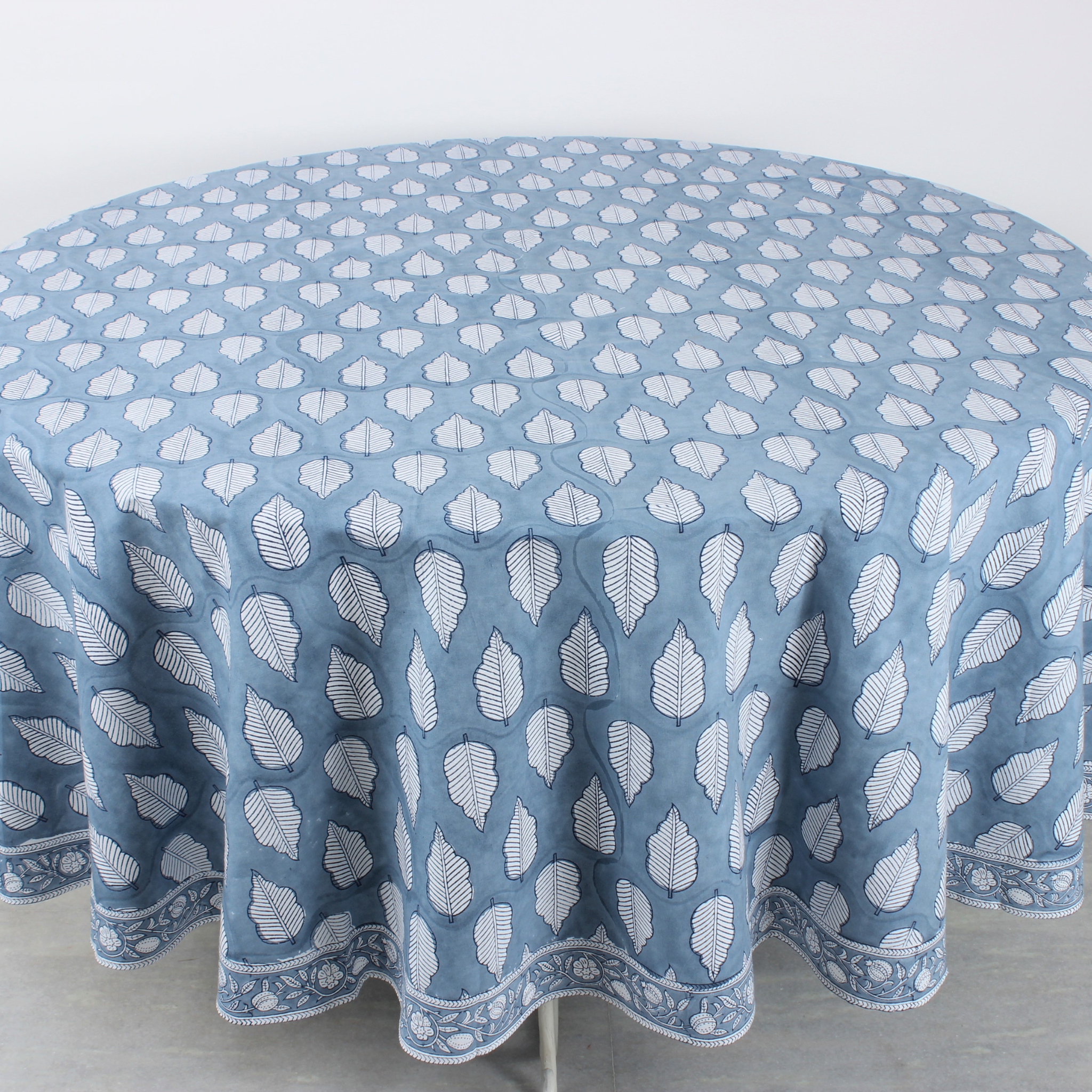 Round tablecloth with white leaf pattern on a blue background