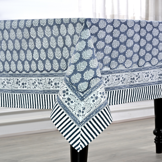 blue and white decorative cotton tablecloth with striped border on wooden table