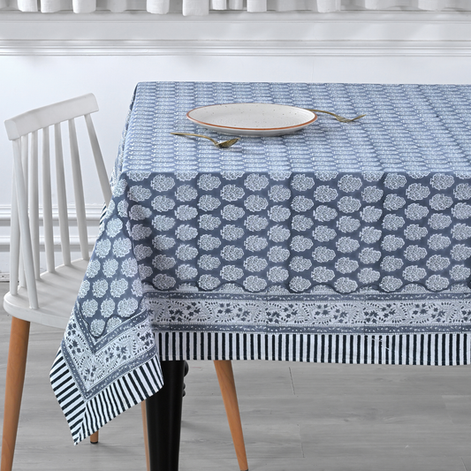 blue and white decorative cotton tablecloth with striped border on wooden table