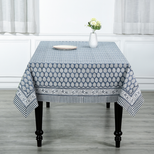 blue and white decorative cotton tablecloth with striped border on wooden table