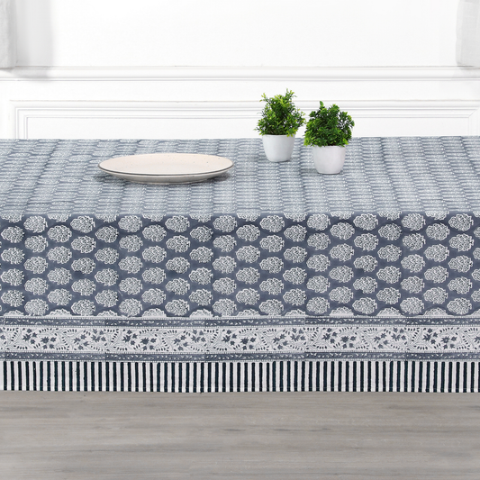 blue and white decorative cotton tablecloth with striped border on wooden table