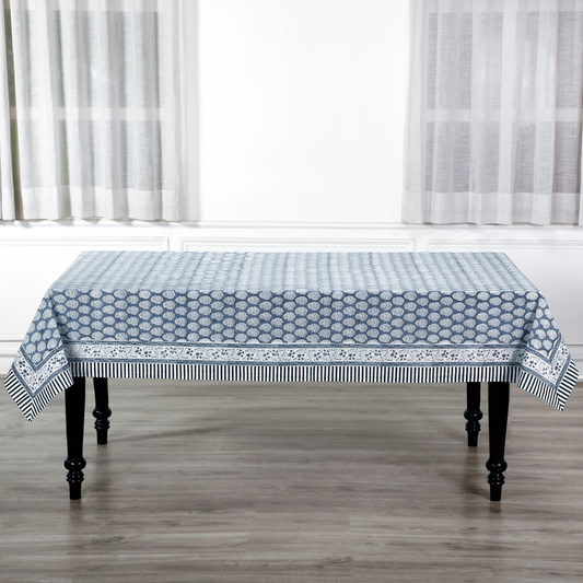 blue and white decorative cotton tablecloth with striped border on wooden table