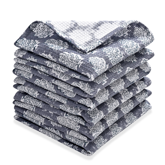 Stack of folded blue and white patterned towels on a white background
