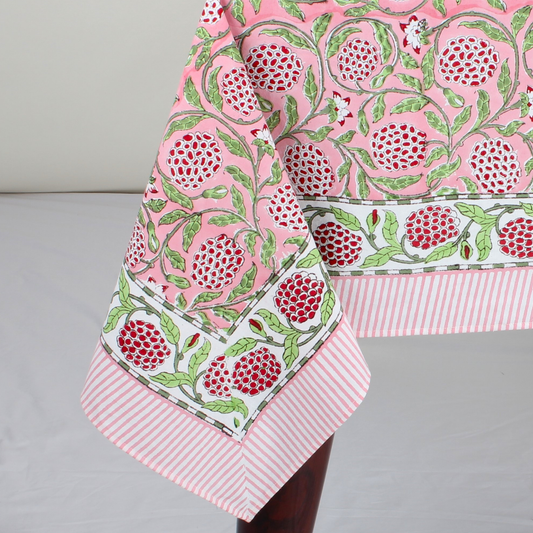 pink decorative tablecloth with striped border on wooden