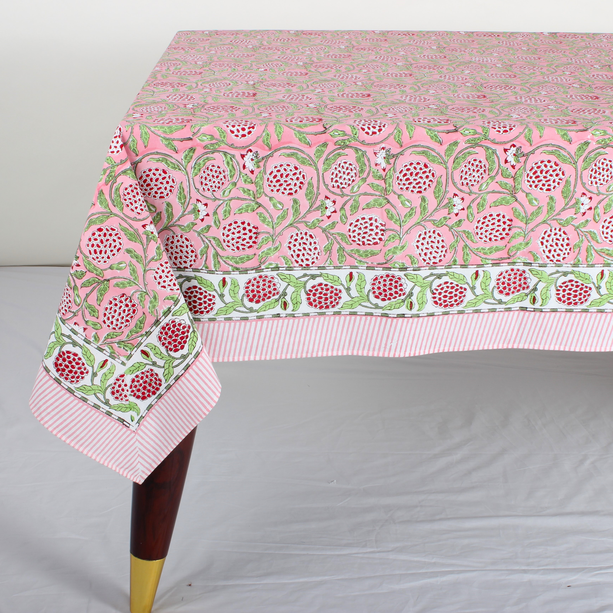 pink decorative tablecloth with striped border on wooden