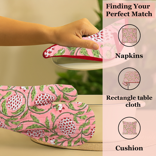 Pink floral tablecloth with matching napkins and other home decor items on a beige background.