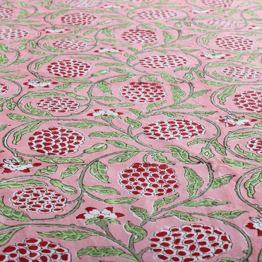 pink decorative tablecloth with striped border on wooden