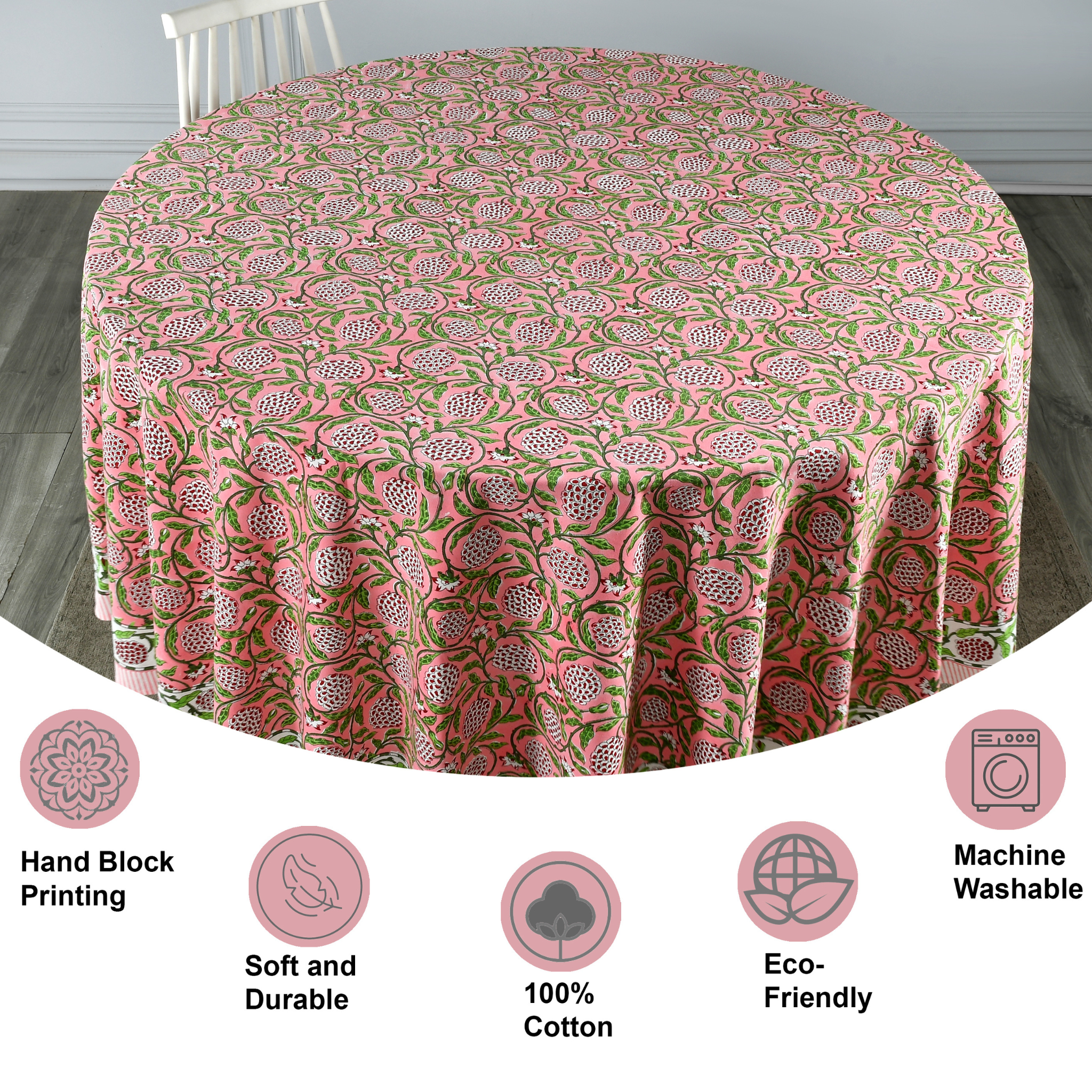 Round tablecloth with pink and green floral pattern on a wooden floor.