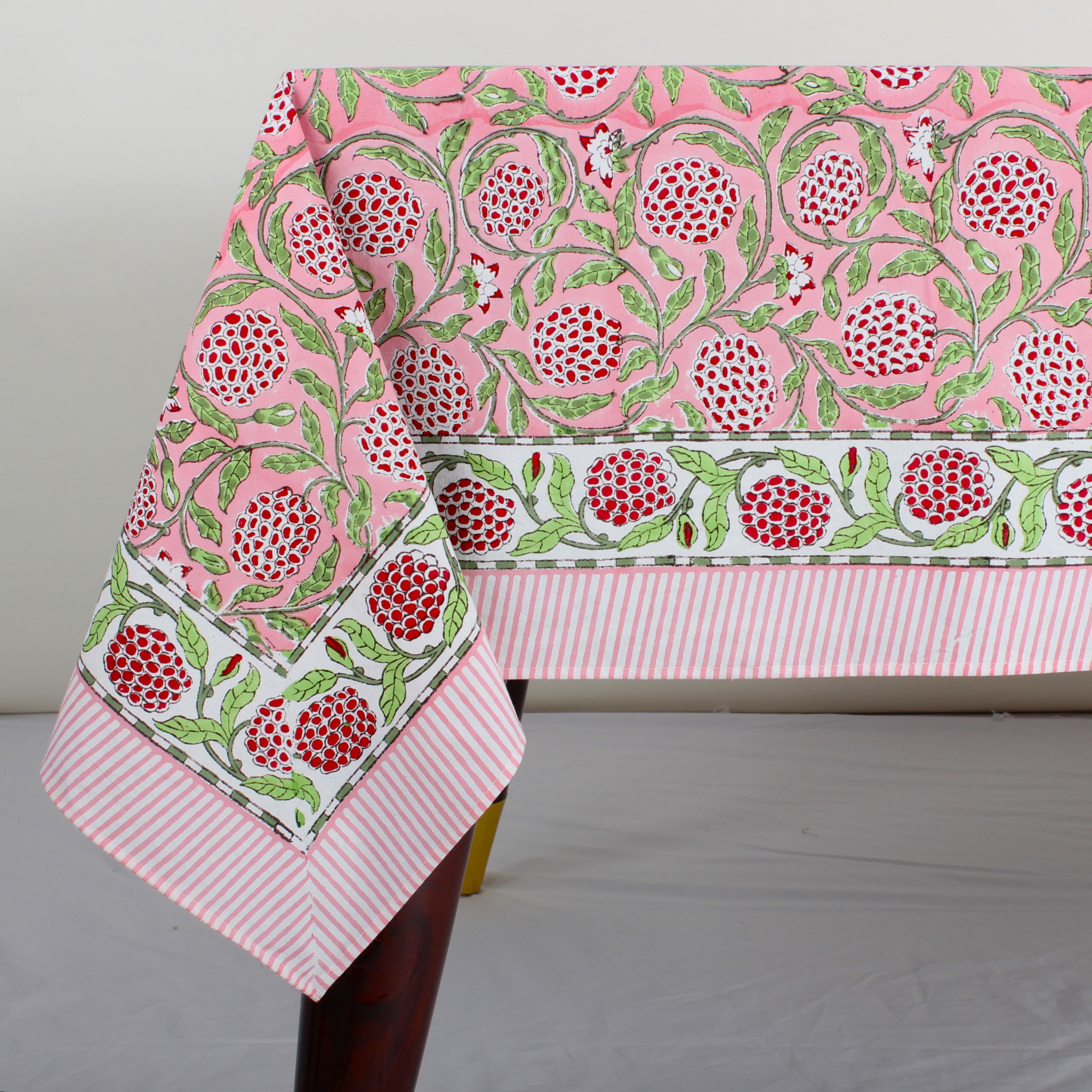 pink decorative tablecloth with striped border on wooden