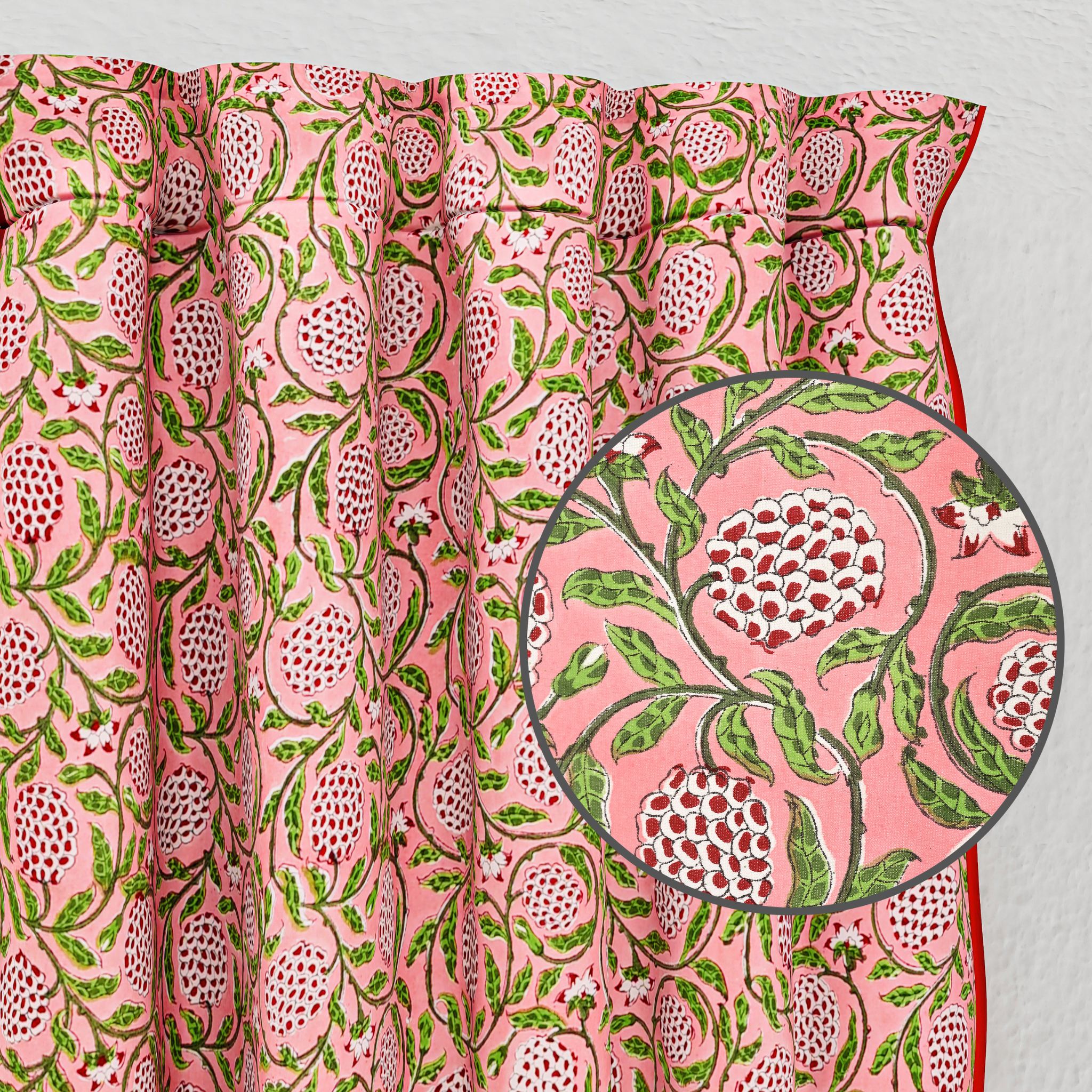 Pink fabric with green and white floral pattern, close-up of design.