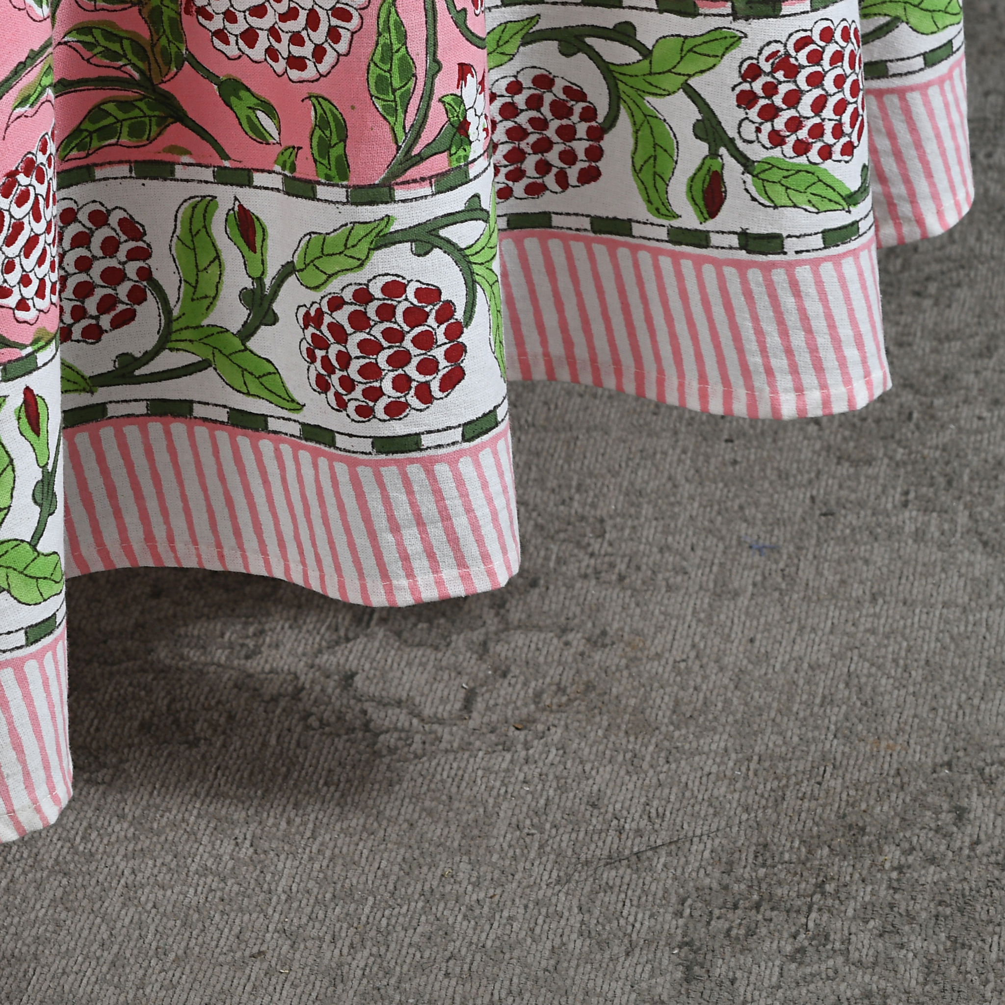 Close-up of a fabric with floral and striped patterns on a gray surface
