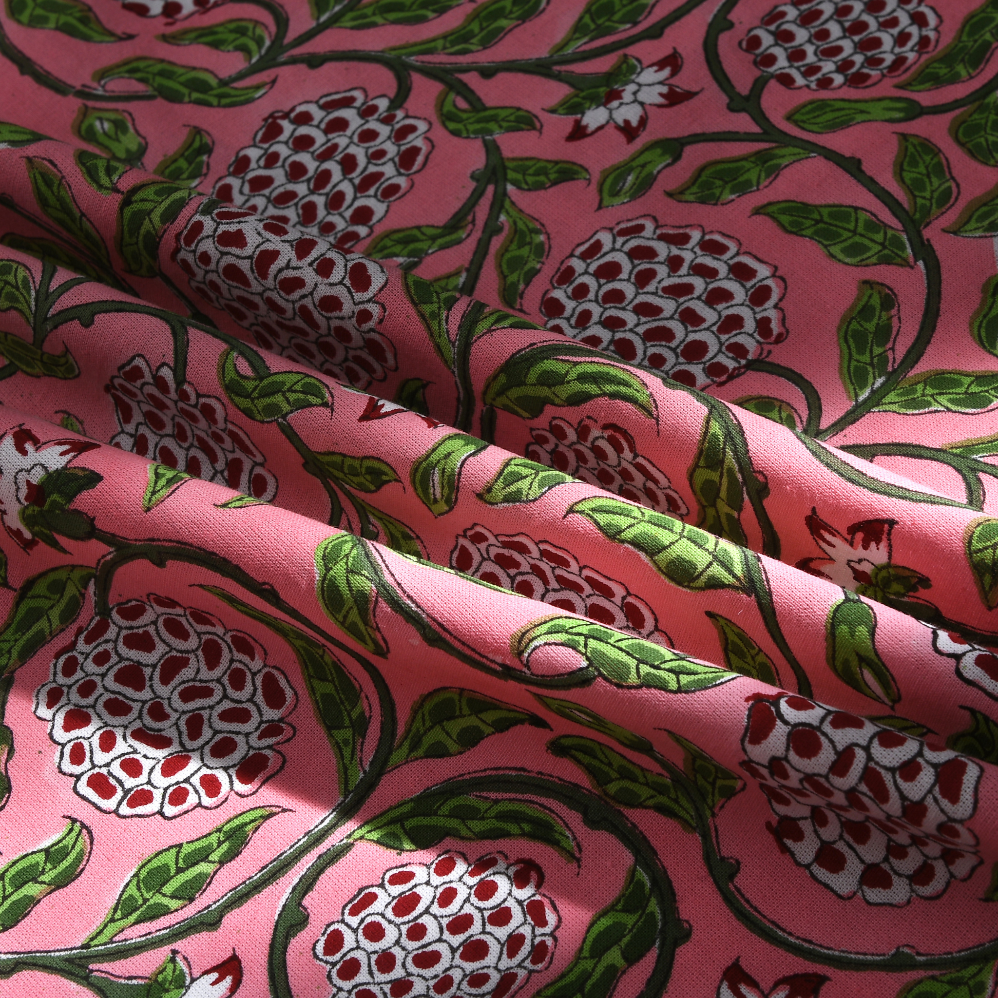 Fabric with pomegranate pattern on a pink background