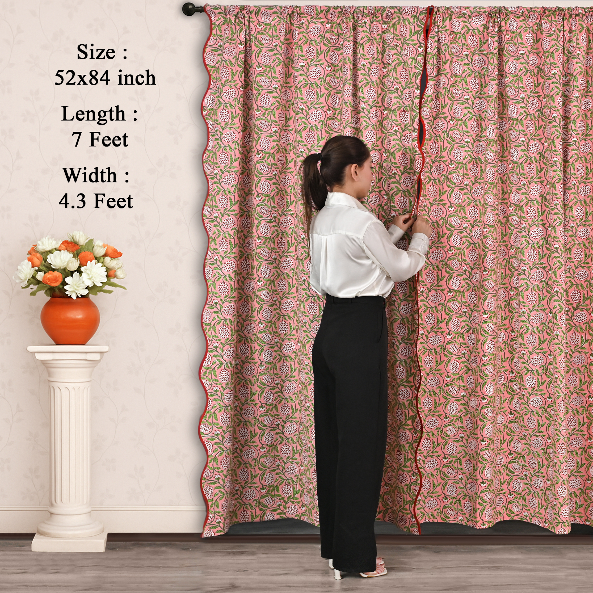 Woman adjusting a long floral curtain with measurements displayed.