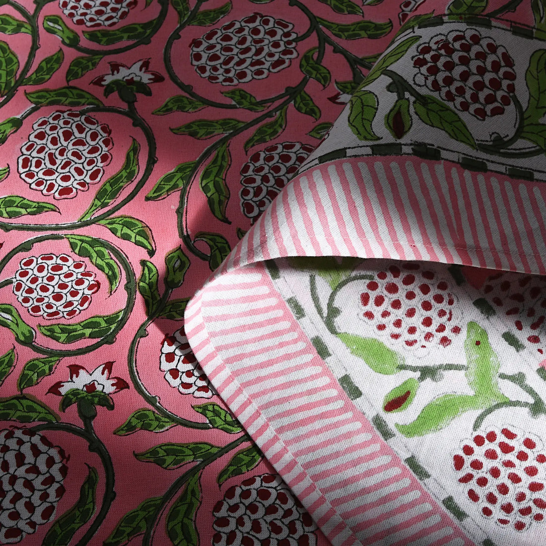 Close-up of floral and striped fabric patterns on a pink background