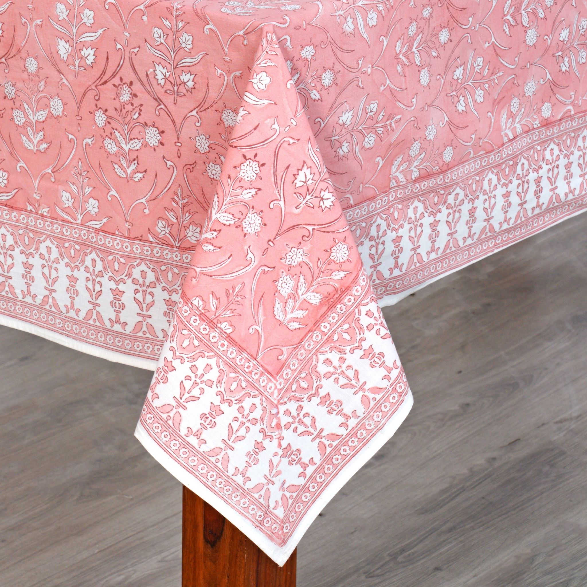 Pink floral patterned tablecloth on a wooden table