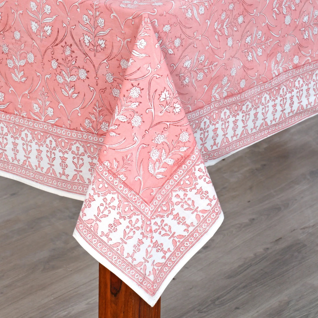 Pink floral patterned tablecloth on a wooden table