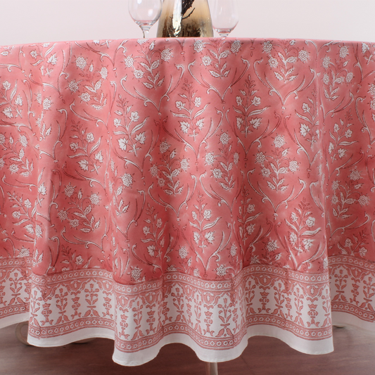 Pink floral patterned tablecloth on a table with glasses.