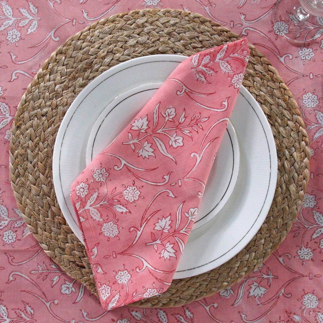 Dining table set with a pink tablecloth and pink napkins