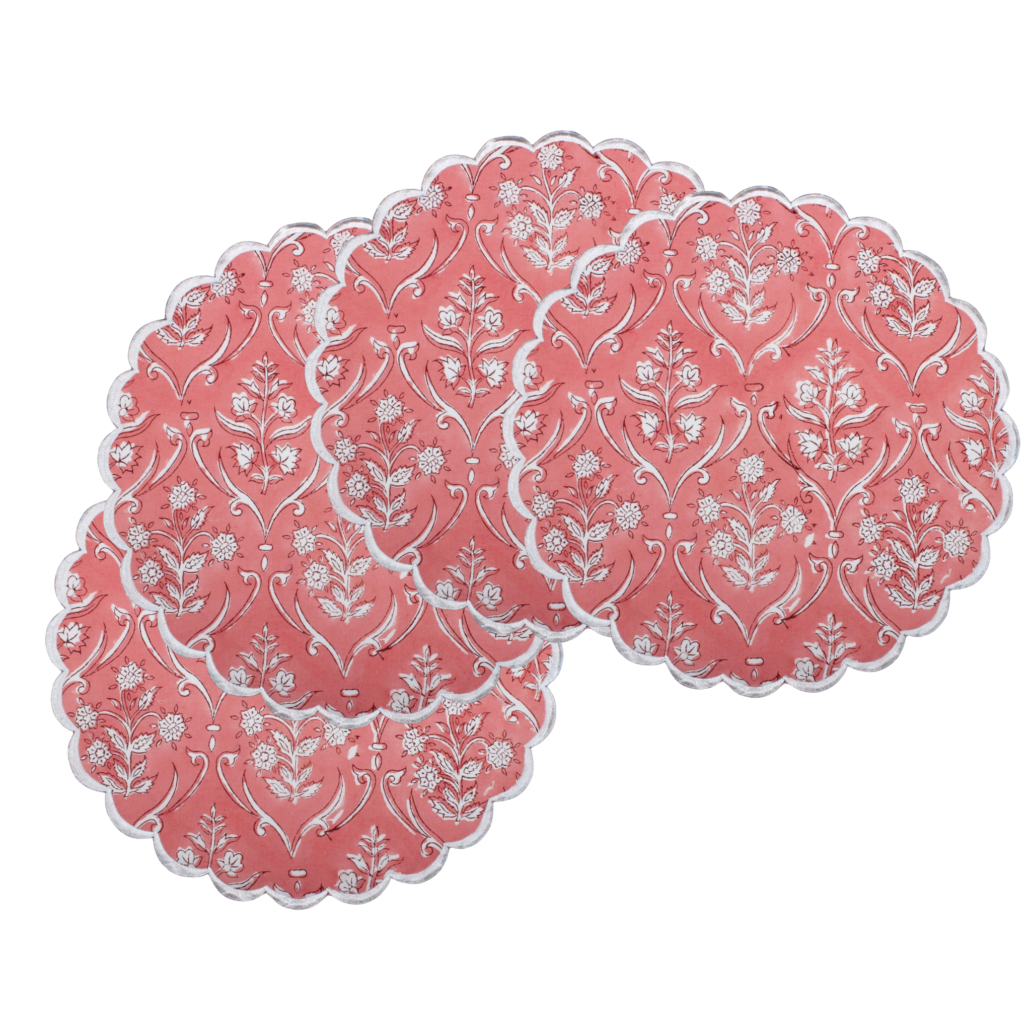 Set of pink placemats with white floral patterns on a white background