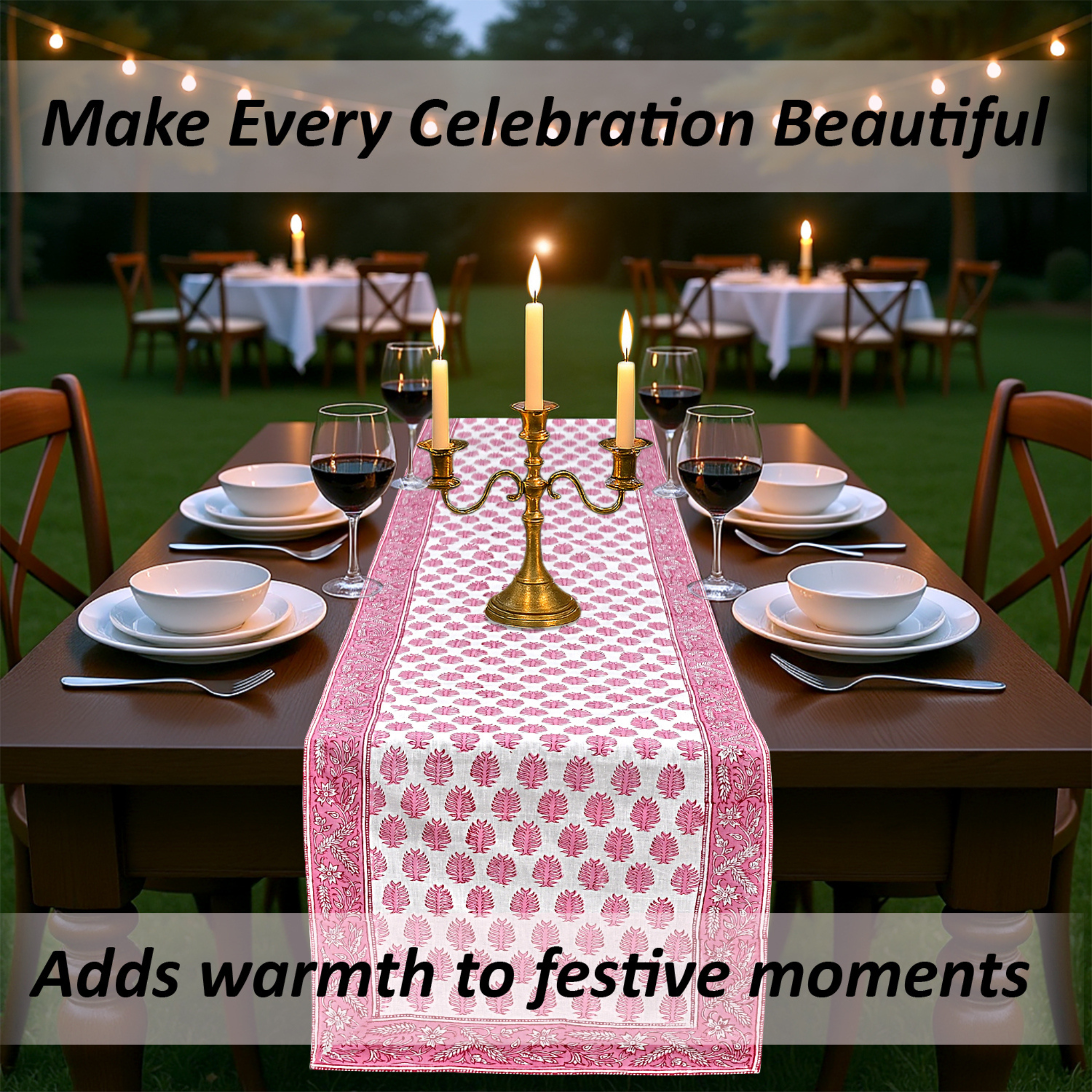 Dining table set with a pink floral table runner, candles, and wine glasses outdoors.