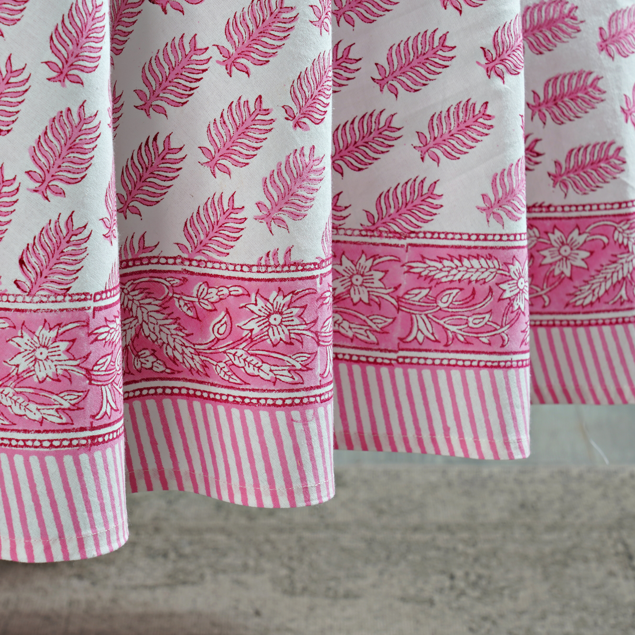 Close-up of pink and white patterned fabric on a textured surface