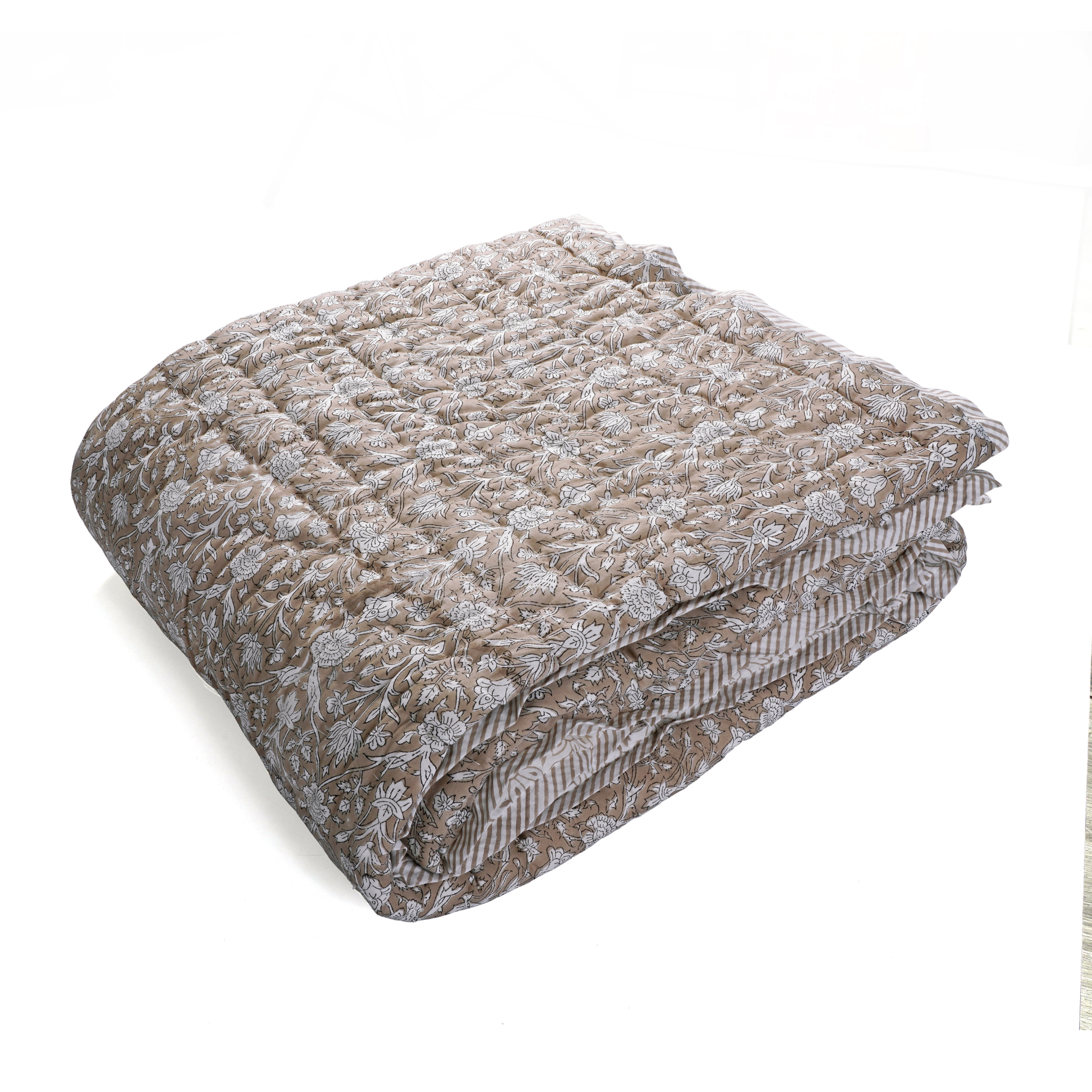 Folded quilt with floral pattern on a white background