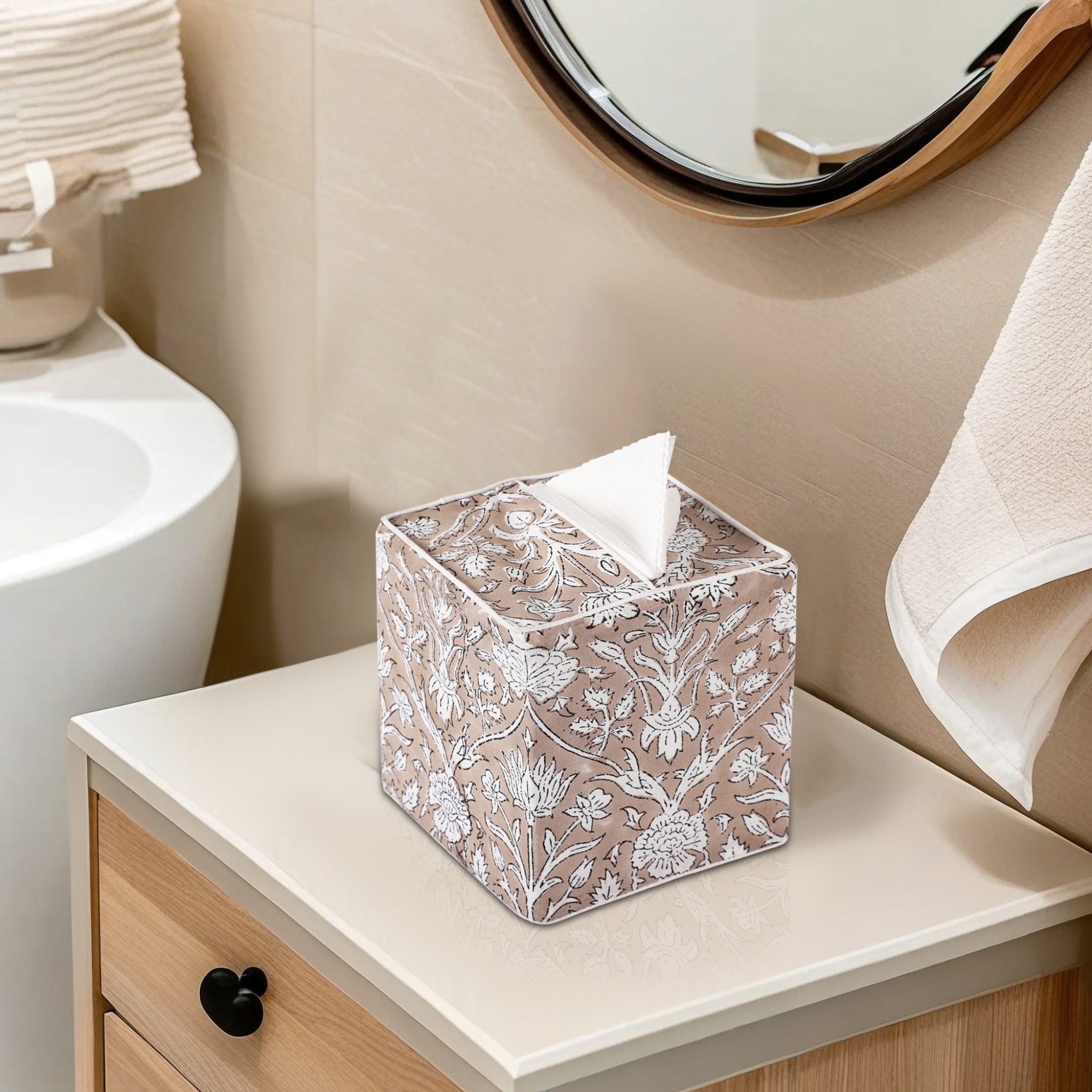 Decorative tissue box on a bathroom counter with a sink and mirror in the background.
