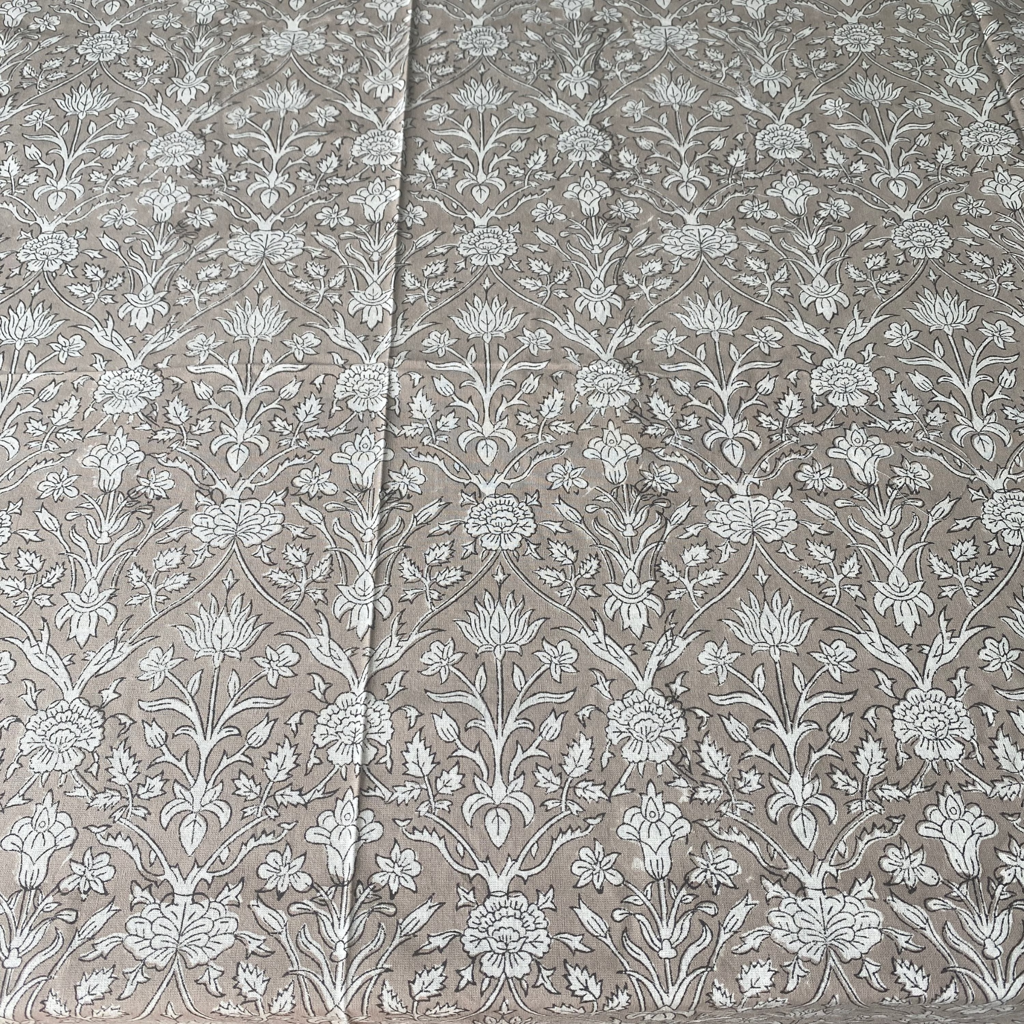 Floral patterned fabric with white flowers on a beige background