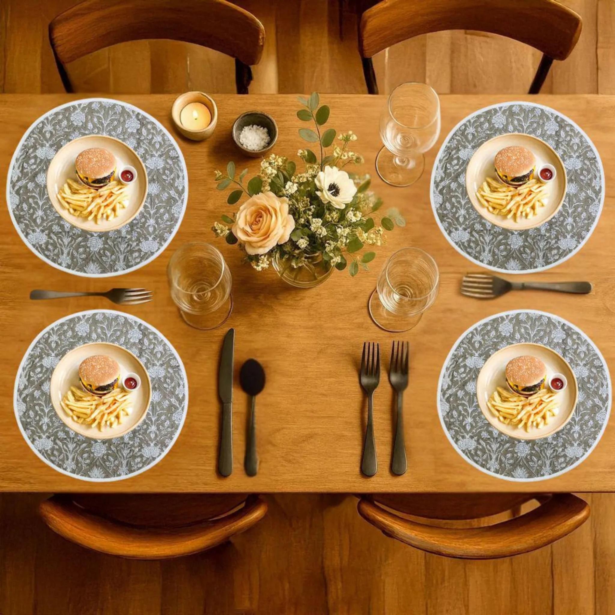 Dining table set with plates, cutlery, and a floral centerpiece.