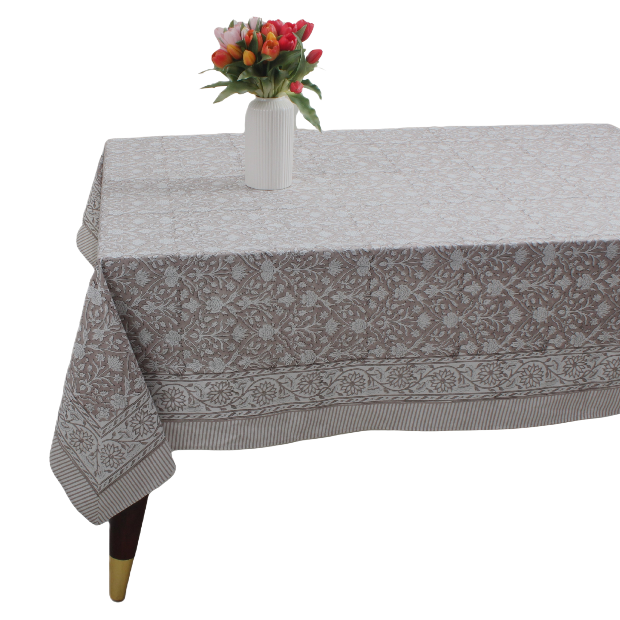 Tablecloth with floral pattern on a table with a vase of flowers.