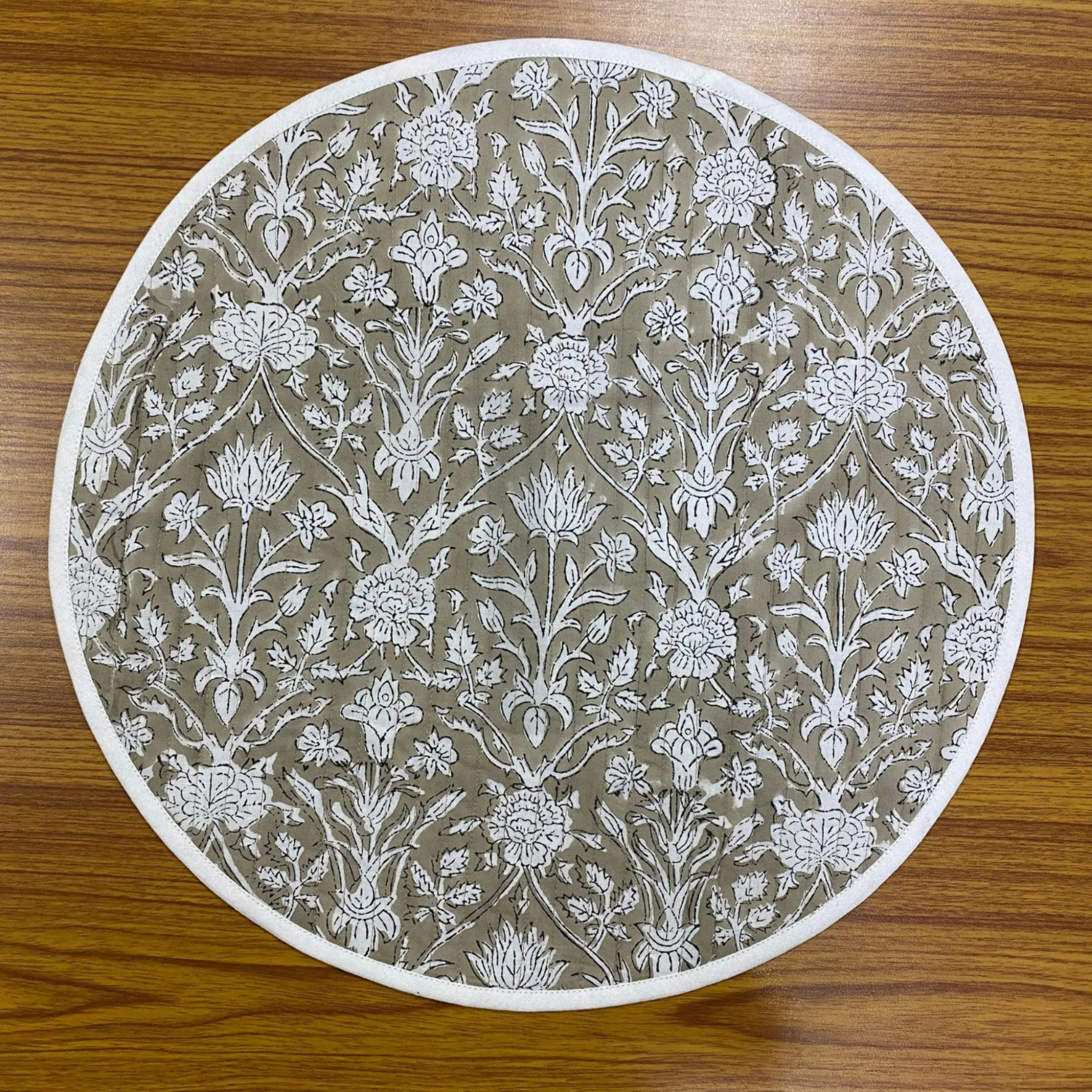 Round placemat with floral pattern on a wooden surface