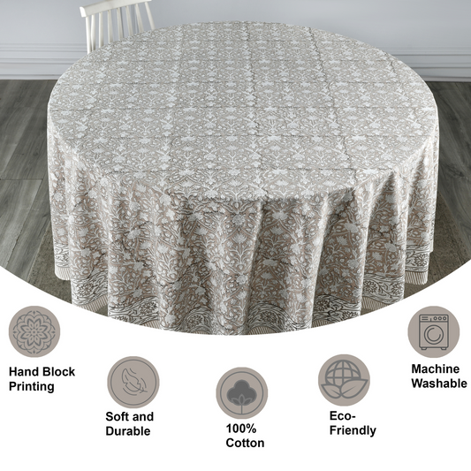 Round tablecloth with floral pattern on a wooden floor, featuring icons and text about material and care.